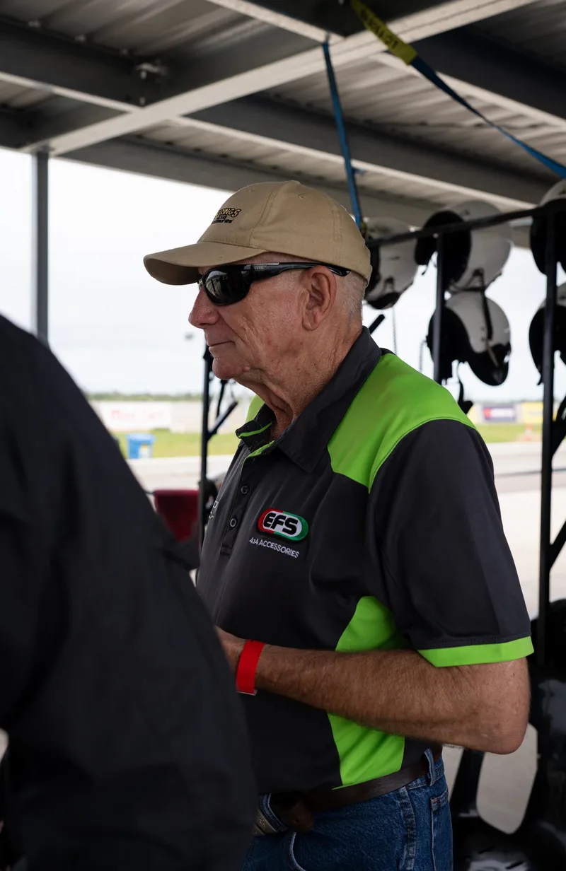 Race-day guest wearing an EFS shirt beside the helmet racks